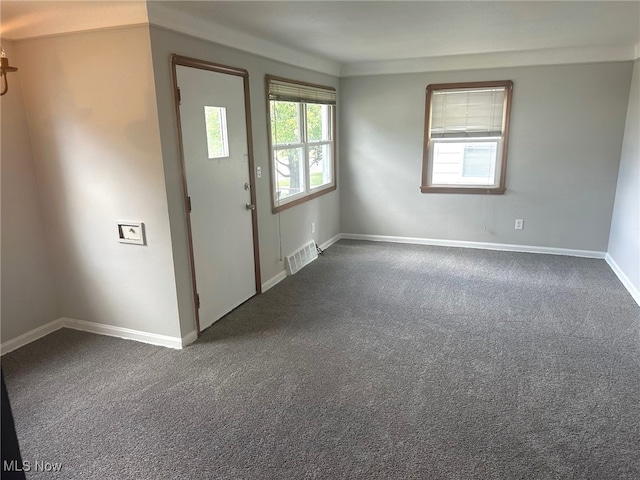 entryway featuring dark colored carpet and a wealth of natural light