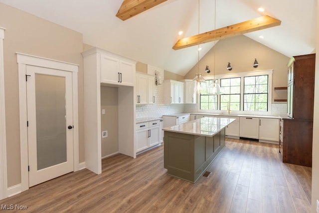 kitchen featuring a center island, dark wood-type flooring, tasteful backsplash, beam ceiling, and white cabinetry