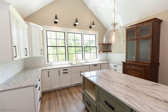 kitchen with decorative backsplash, dark wood-type flooring, sink, decorative light fixtures, and white cabinetry