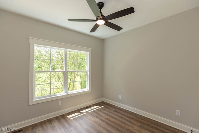 unfurnished room with ceiling fan and dark wood-type flooring