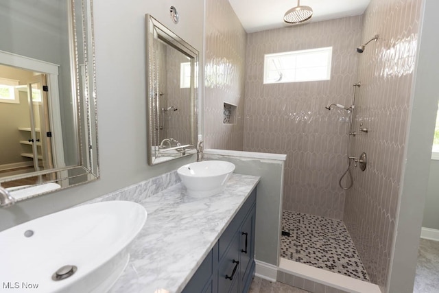 bathroom featuring a tile shower and vanity