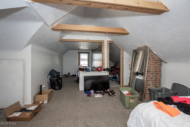 carpeted bedroom with vaulted ceiling with beams and a textured ceiling