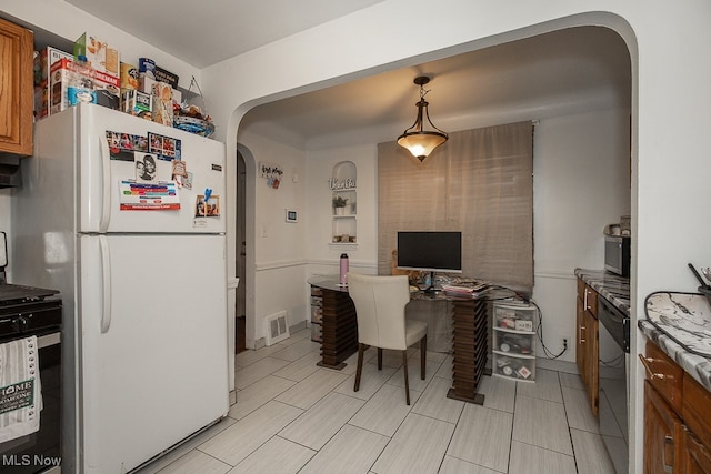 kitchen featuring built in desk, decorative light fixtures, range, stainless steel dishwasher, and white fridge