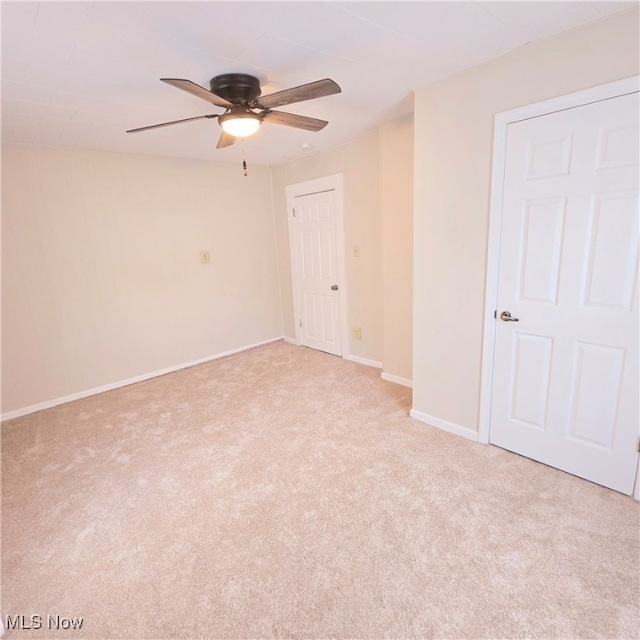 empty room featuring light colored carpet and ceiling fan