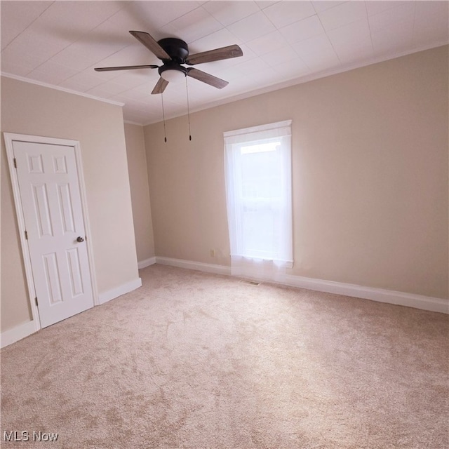 carpeted empty room featuring ornamental molding and ceiling fan