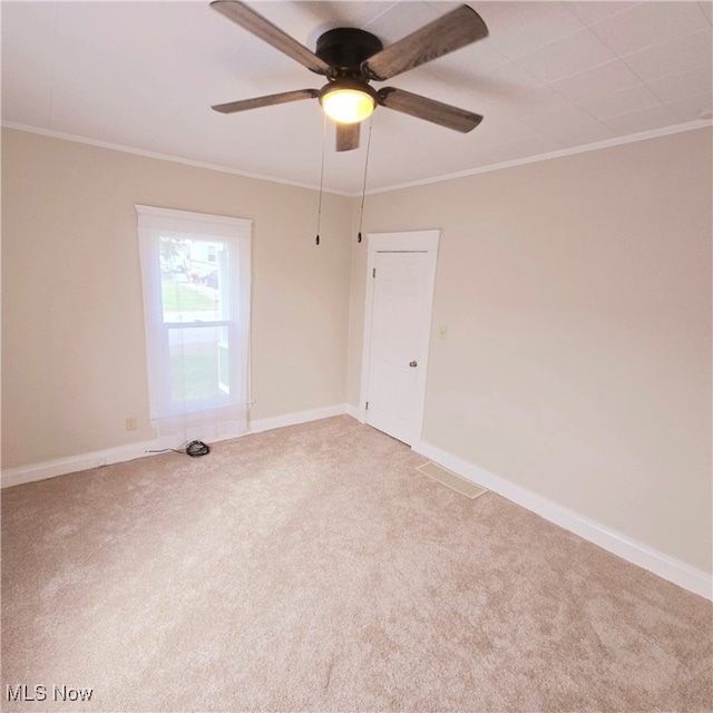 empty room featuring crown molding, carpet, and ceiling fan