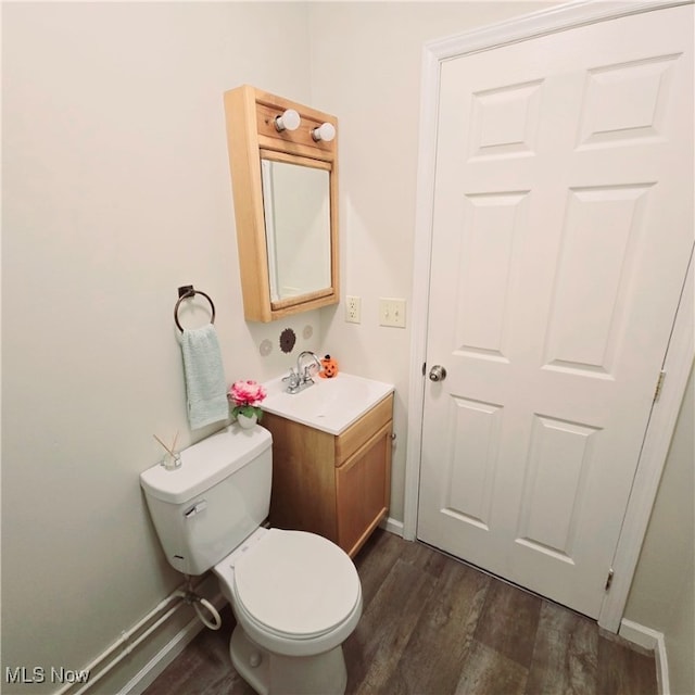 bathroom with vanity, toilet, and wood-type flooring