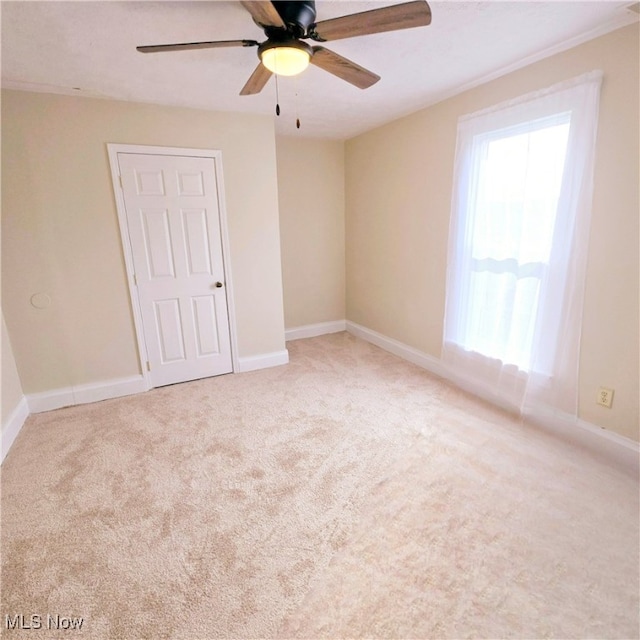 carpeted spare room with ceiling fan