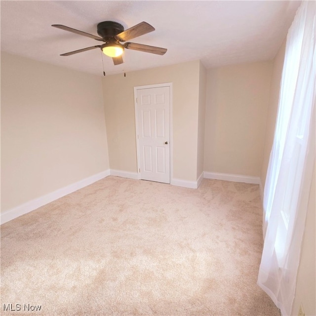 unfurnished room featuring light colored carpet and ceiling fan