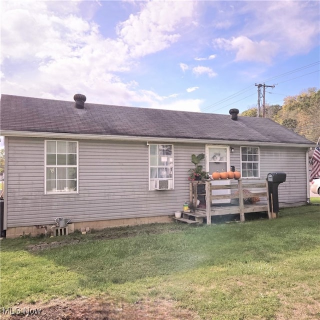 rear view of property with a wooden deck and a lawn