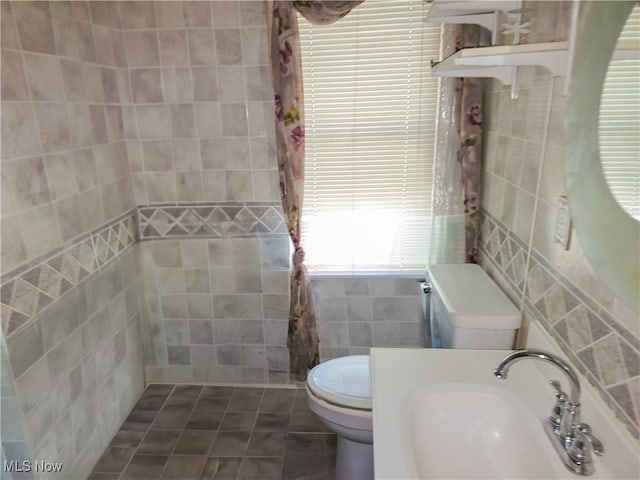 bathroom featuring tile walls, sink, toilet, and tile patterned floors