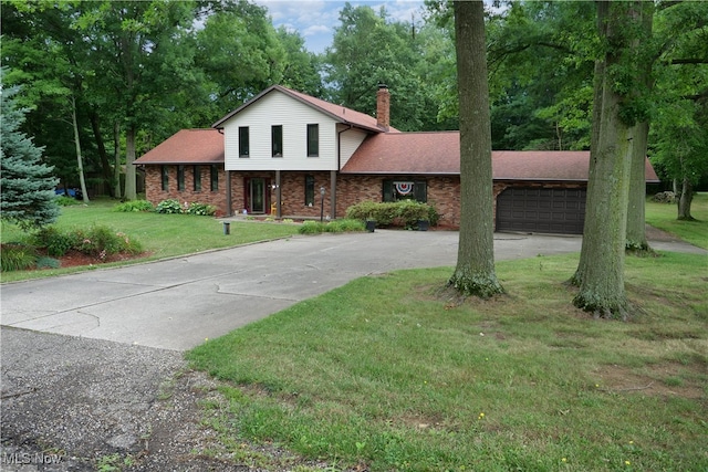 split level home with a garage and a front lawn