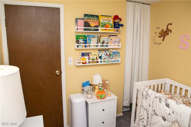 bedroom with carpet and a crib