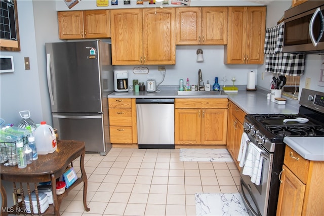 kitchen featuring sink, light tile patterned flooring, and appliances with stainless steel finishes