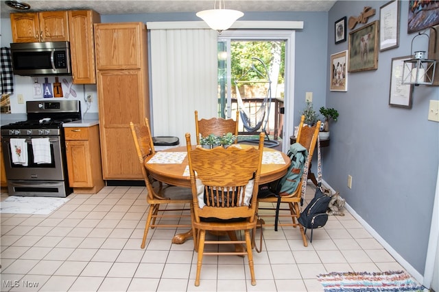 tiled dining room featuring a textured ceiling