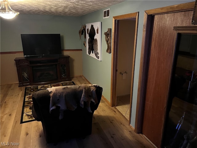 living room featuring a textured ceiling and light hardwood / wood-style flooring