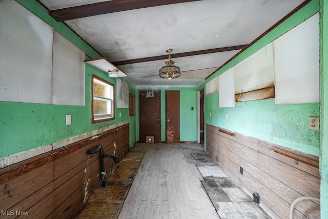 kitchen featuring hardwood / wood-style flooring, beamed ceiling, and wood walls