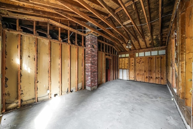 misc room with lofted ceiling and concrete floors