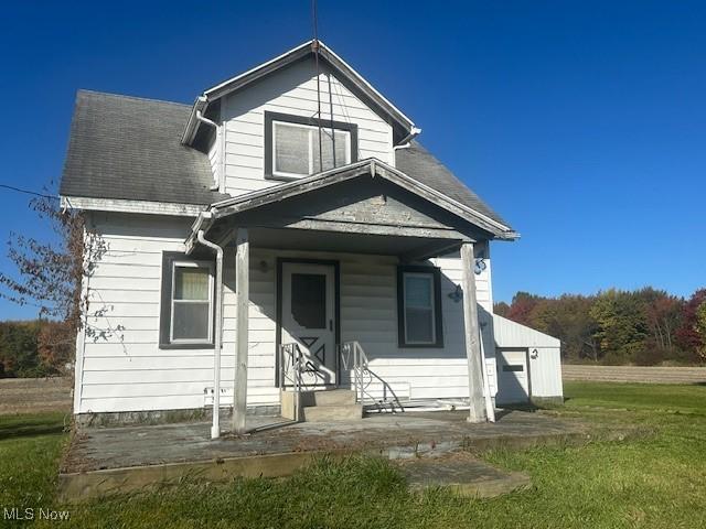 7433 State Route 7, Andover, OH 44003 - view of front facade with a front yard, covered porch, and a shingled roof