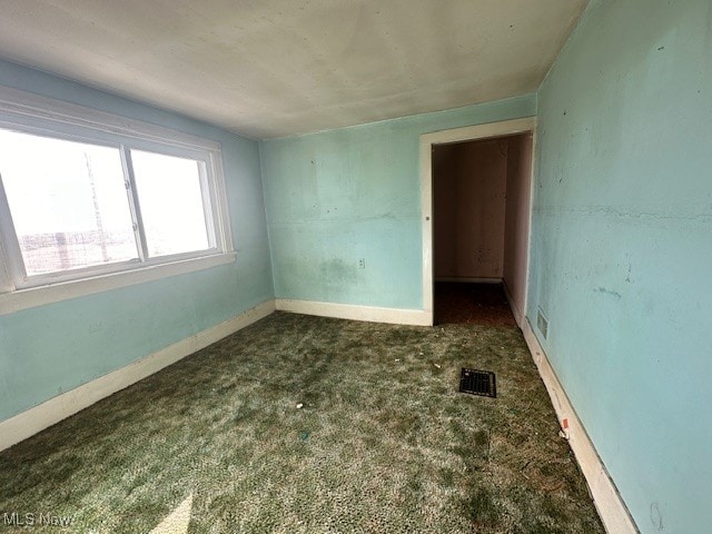 spare room featuring dark carpet