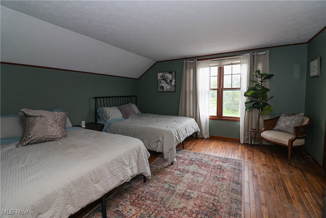 bedroom with lofted ceiling and wood-type flooring