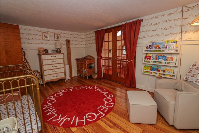 interior space featuring french doors, a textured ceiling, and hardwood / wood-style floors