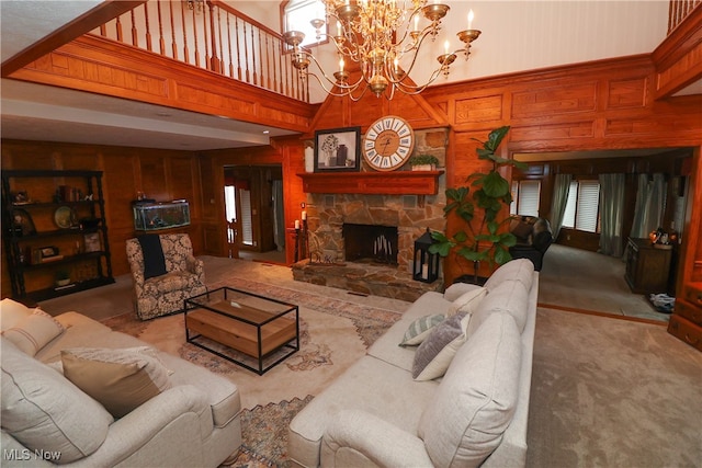 carpeted living room with a towering ceiling, a chandelier, wooden walls, and a fireplace