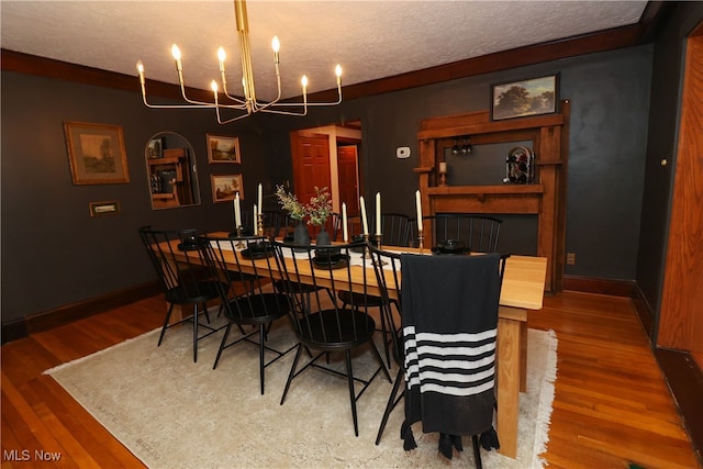 dining room featuring a notable chandelier, a textured ceiling, and hardwood / wood-style floors