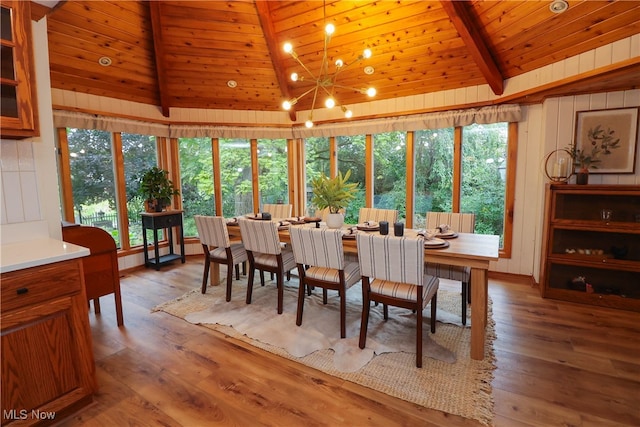 dining area with a wealth of natural light, lofted ceiling with beams, hardwood / wood-style flooring, and wooden ceiling