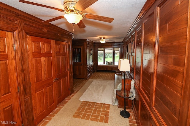 interior space featuring a textured ceiling and wood walls