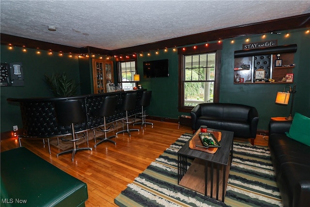 bar featuring wood-type flooring and a textured ceiling