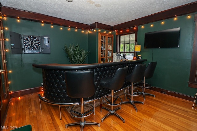 bar with a textured ceiling and wood-type flooring