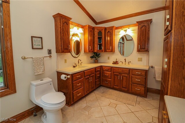 bathroom featuring toilet, lofted ceiling, vanity, decorative backsplash, and tile patterned flooring