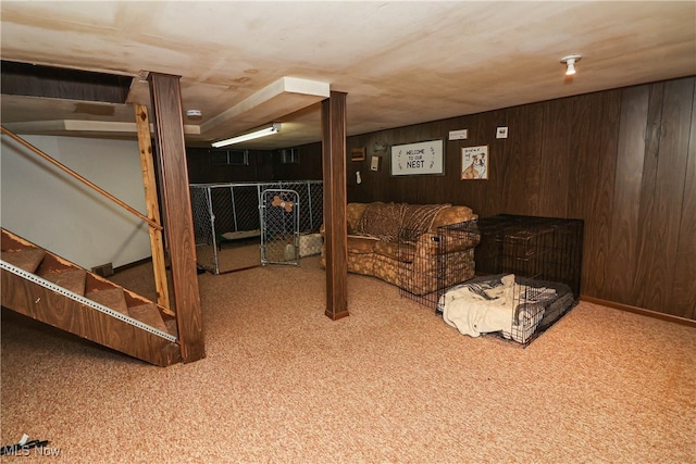 basement with wooden walls and light colored carpet