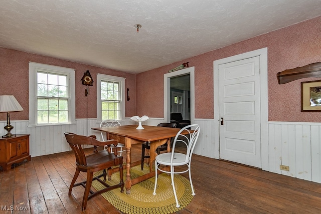 dining area featuring a textured ceiling and dark hardwood / wood-style flooring