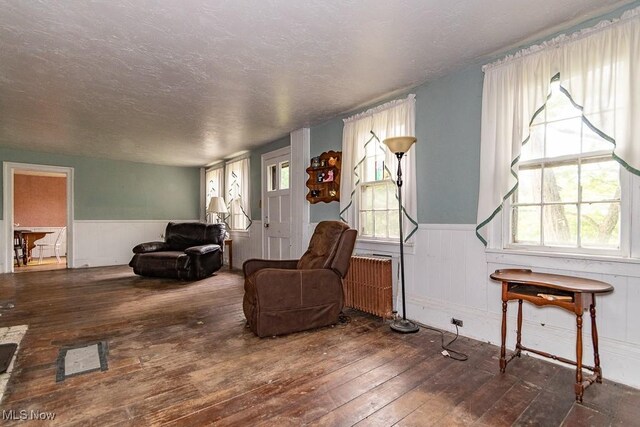 living room featuring radiator, a textured ceiling, and dark hardwood / wood-style floors