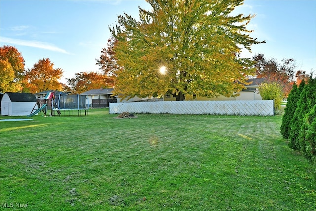 view of yard with a trampoline and a playground