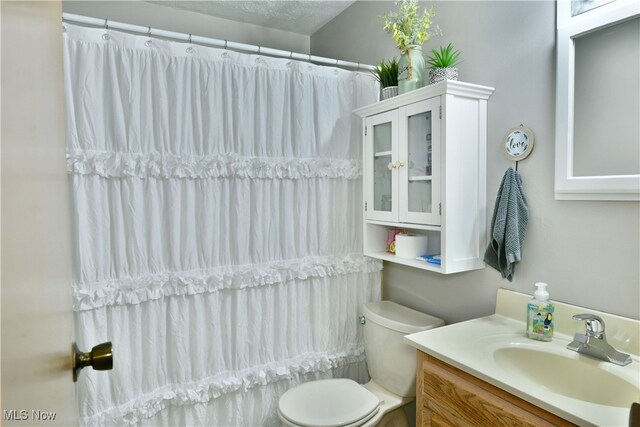 full bathroom with vanity, a textured ceiling, toilet, and shower / tub combo with curtain