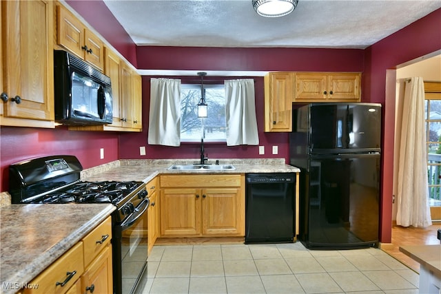 kitchen with sink, decorative light fixtures, a healthy amount of sunlight, and black appliances