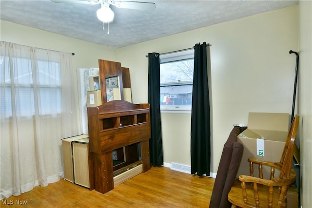 interior space featuring ceiling fan, a textured ceiling, and light hardwood / wood-style flooring