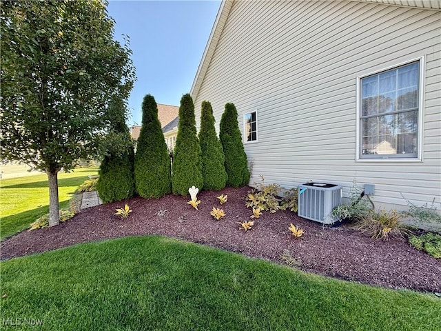 view of home's exterior with a lawn and central air condition unit