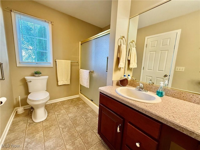 bathroom featuring tile patterned floors, a shower with door, vanity, and toilet