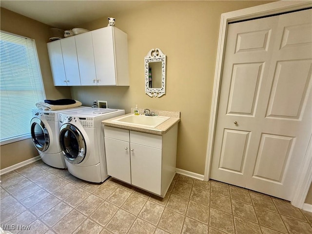 clothes washing area featuring washing machine and clothes dryer, sink, light tile patterned flooring, and cabinets