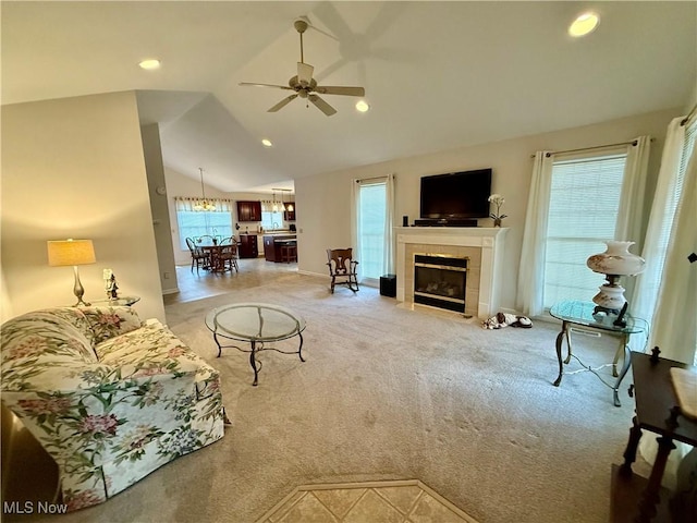 living room featuring a tile fireplace, carpet flooring, a wealth of natural light, and ceiling fan