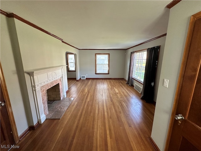 unfurnished living room featuring ornamental molding and dark hardwood / wood-style flooring