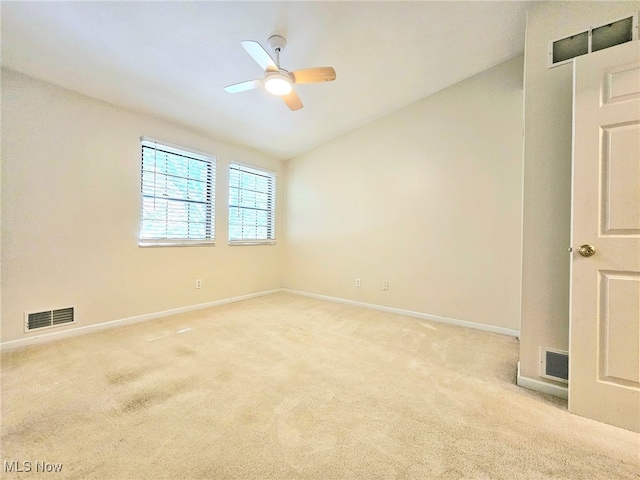 spare room featuring ceiling fan, lofted ceiling, and light colored carpet