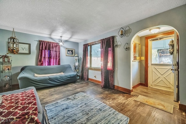 unfurnished bedroom featuring a textured ceiling and dark hardwood / wood-style flooring