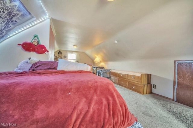 bedroom with lofted ceiling and light colored carpet