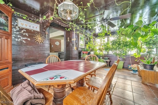 tiled dining space featuring ceiling fan