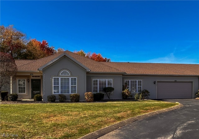 ranch-style house featuring a front yard and a garage